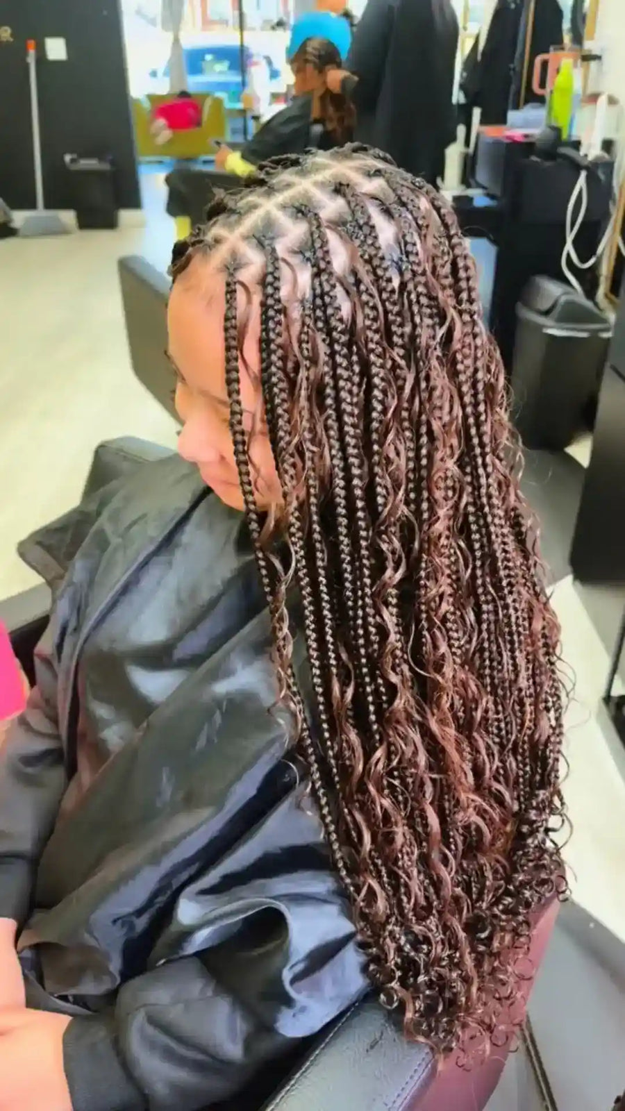 Person with braided hair in a salon setting