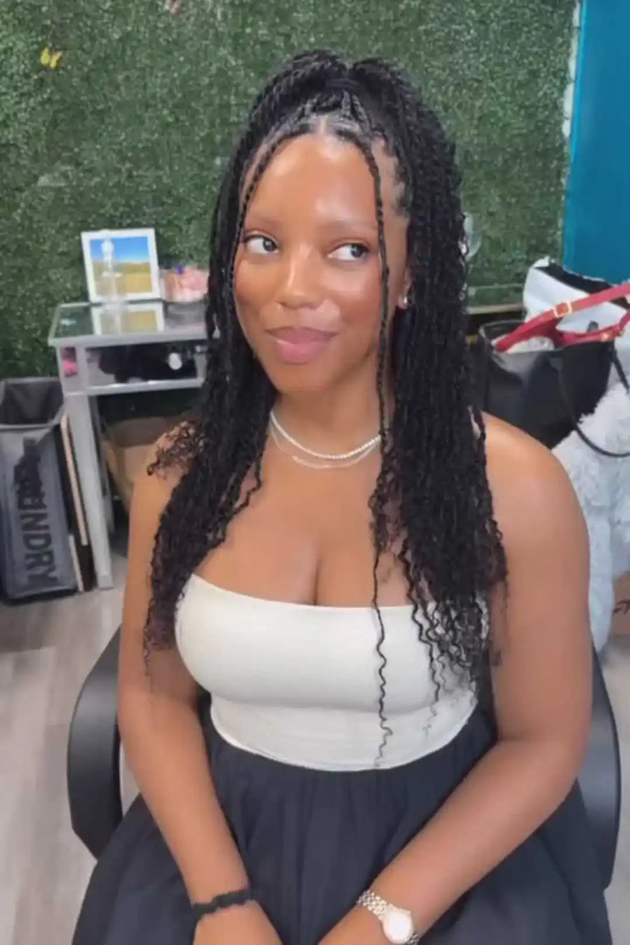 Woman sitting in an office chair with a green wall and office supplies in the background