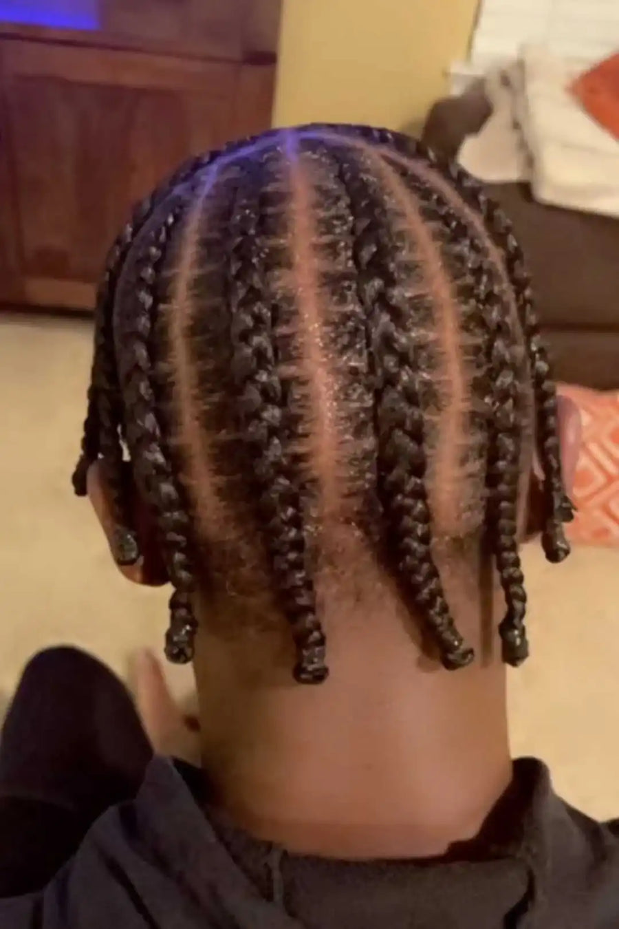 Person with braided hair in a home setting