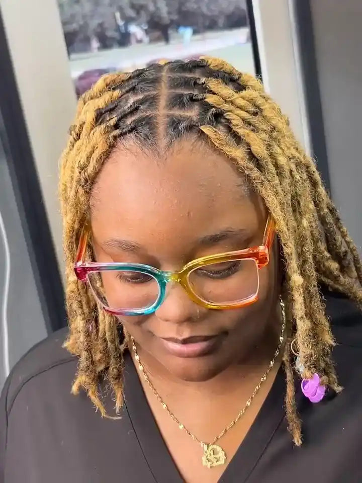 Shoulder-length honey blonde faux locs with dark roots and a center part, hairstylist located in Atmore, AL