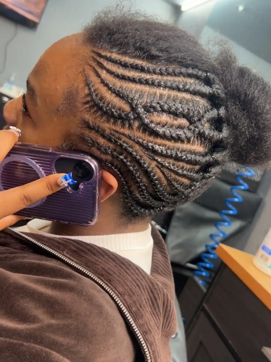 Intricate side feed-in cornrows with curved braid patterns and clean sectioning, hairstylist located in Atmore, AL