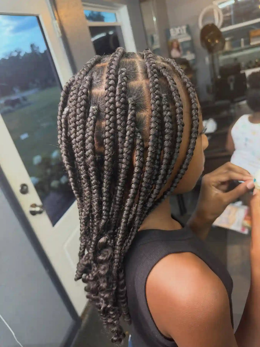 Medium knotless box braids with clean square parts and a shoulder-length finish, hairstylist located in Atmore, AL