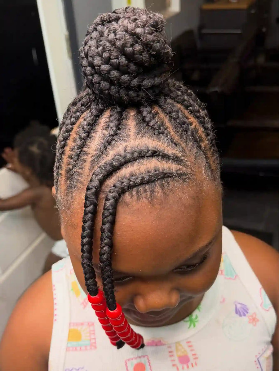 Braided high bun with curved stitch cornrows, two face-framing braids, and red beads, hairstylist located in Atmore, AL