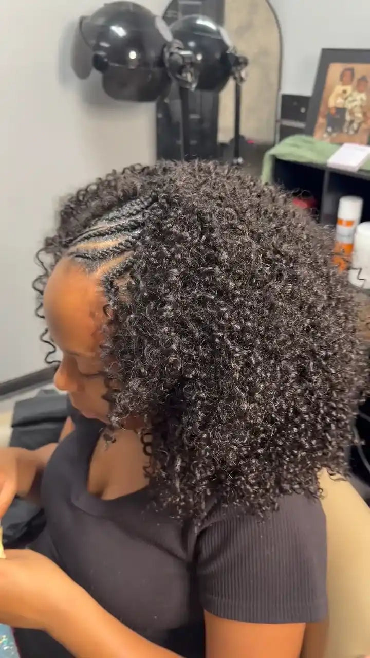 Short voluminous natural black curly hairstyle with side cornrow braids and tightly defined curls, Stylist located in Greensboro, NC