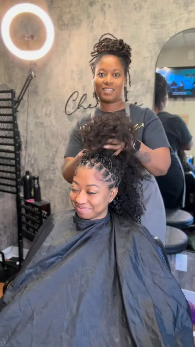 Long black braided hairstyle with loose curly extensions and neatly sectioned roots, Stylist located in Houston, TX