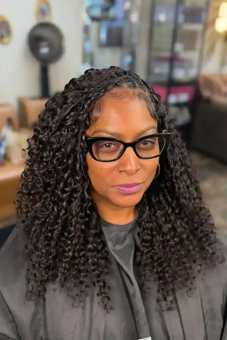 Woman with styled hair and glasses in a casual indoor setting