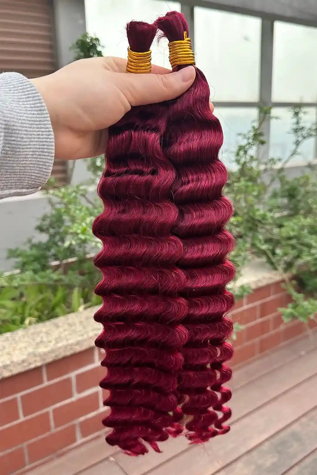 Outdoor picture of the ends of bulk human hair for braiding burgundy red deep wave bu19