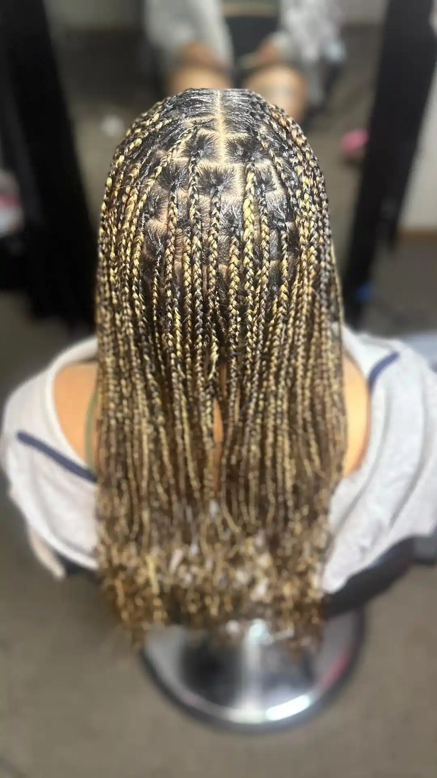 Cornrow hairstyle on a mannequin head with a blurred background