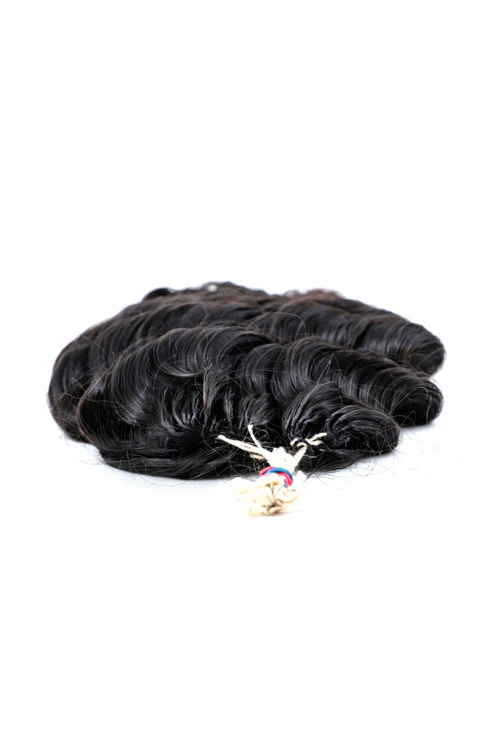 Detail of the ends of handmade feather line hair extensions loose deep wave single strand with loop