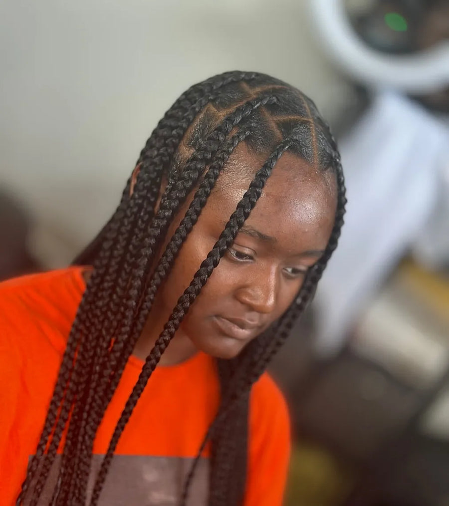 Long jumbo knotless box braids with a center part and face-framing braids, hairstylist located in Fairview Heights, IL