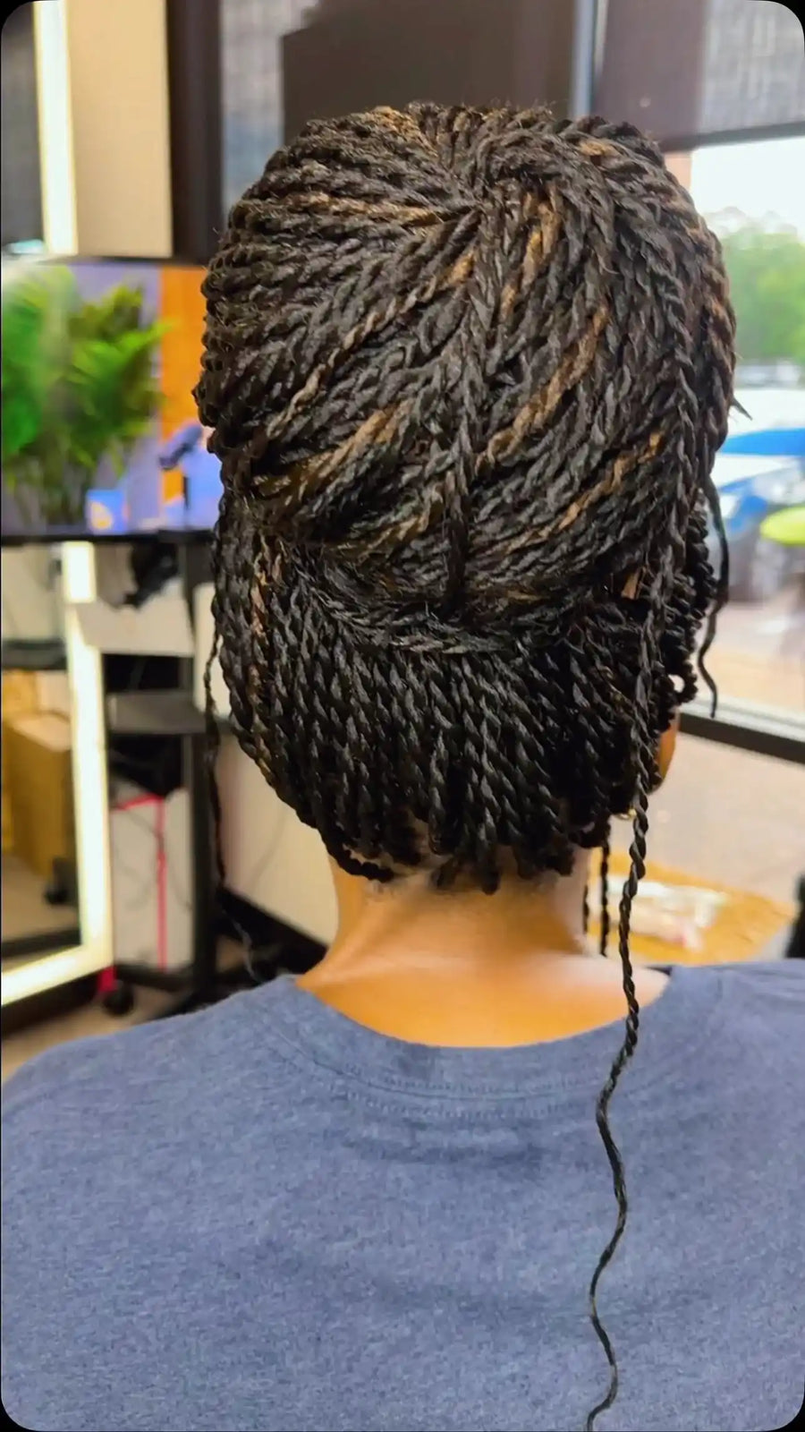 Intricate black and brown mini twists styled into an elegant twisted updo with a neatly tucked low bun, Stylist located in Bartlett, TN