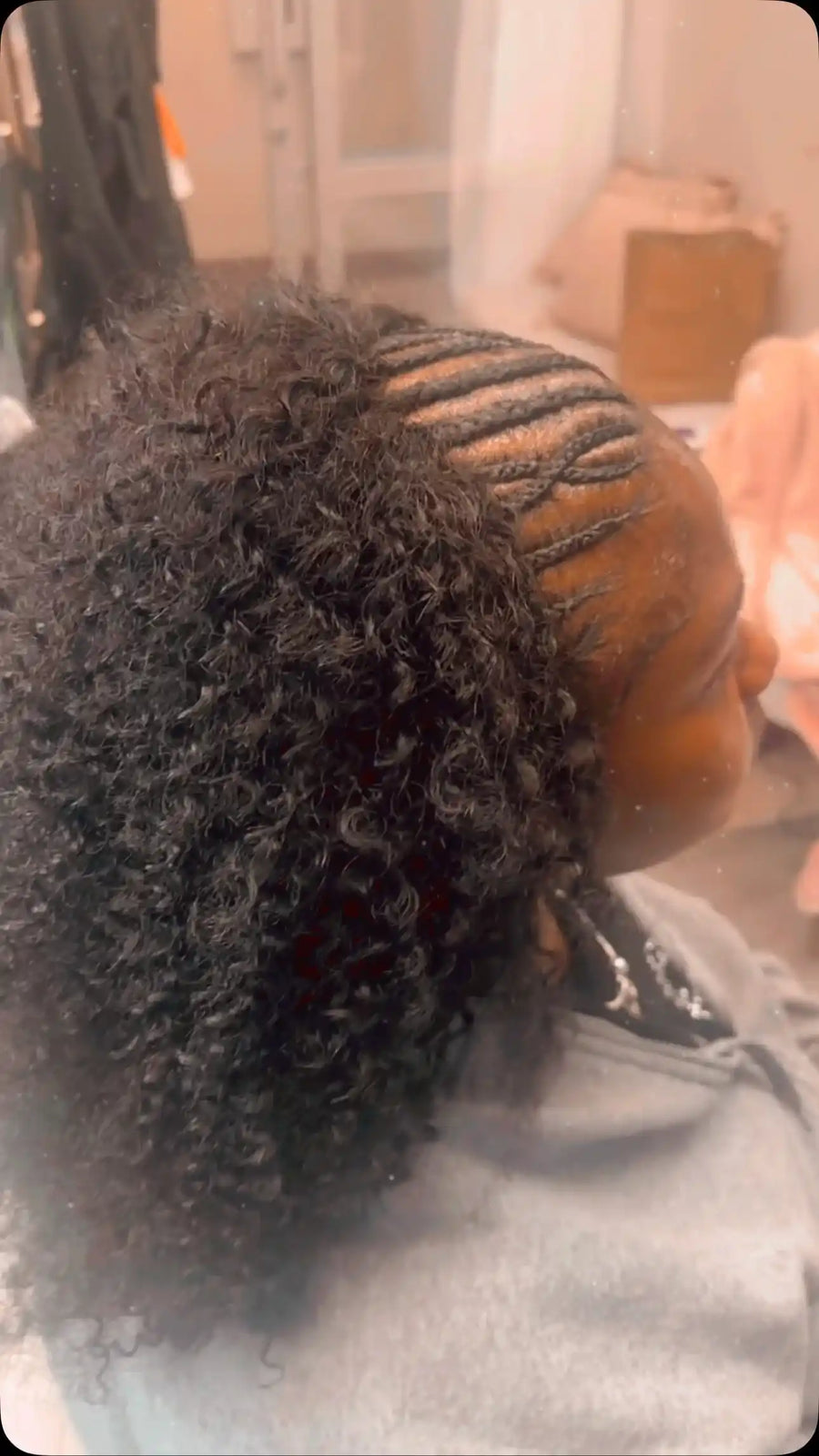 Side cornrow braids styled into a voluminous black curly ponytail with defined natural curls, Stylist located in Bartlett, TN