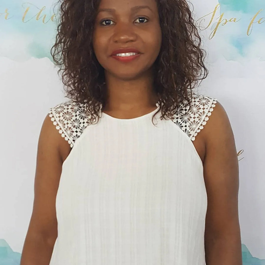Woman wearing a white dress with lace details against a blurred background