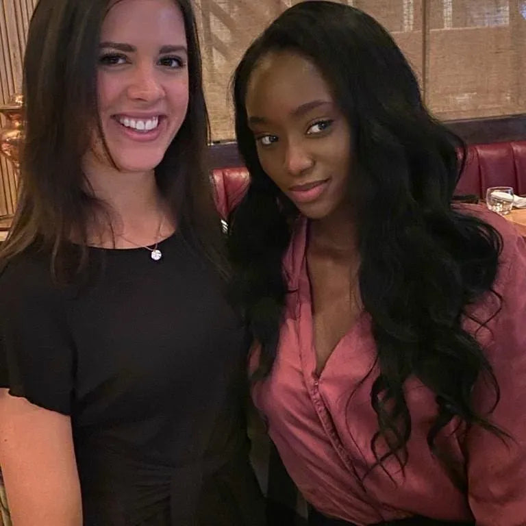 Two women posing for a photo in an indoor setting