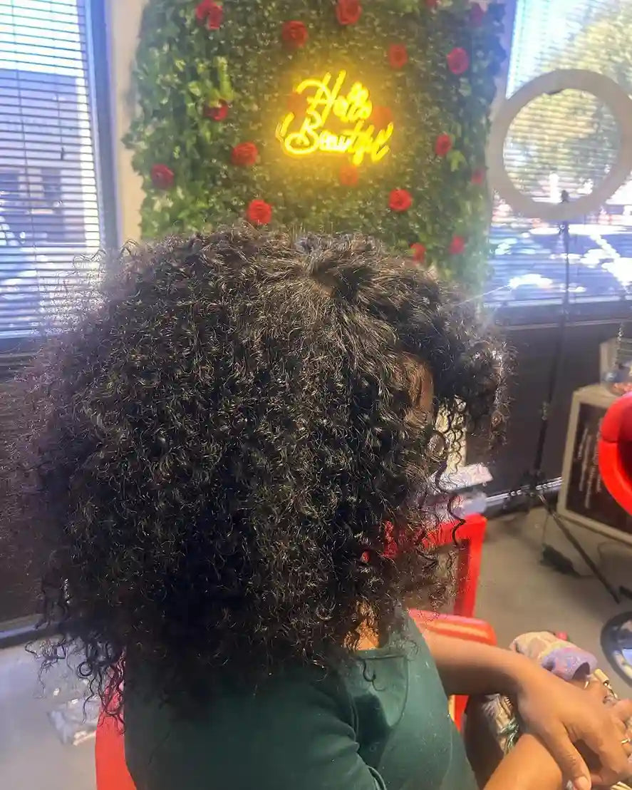 Full natural curly hairstyle with defined coils and rounded shoulder-length volume, hairstylist located in Glendale, AZ