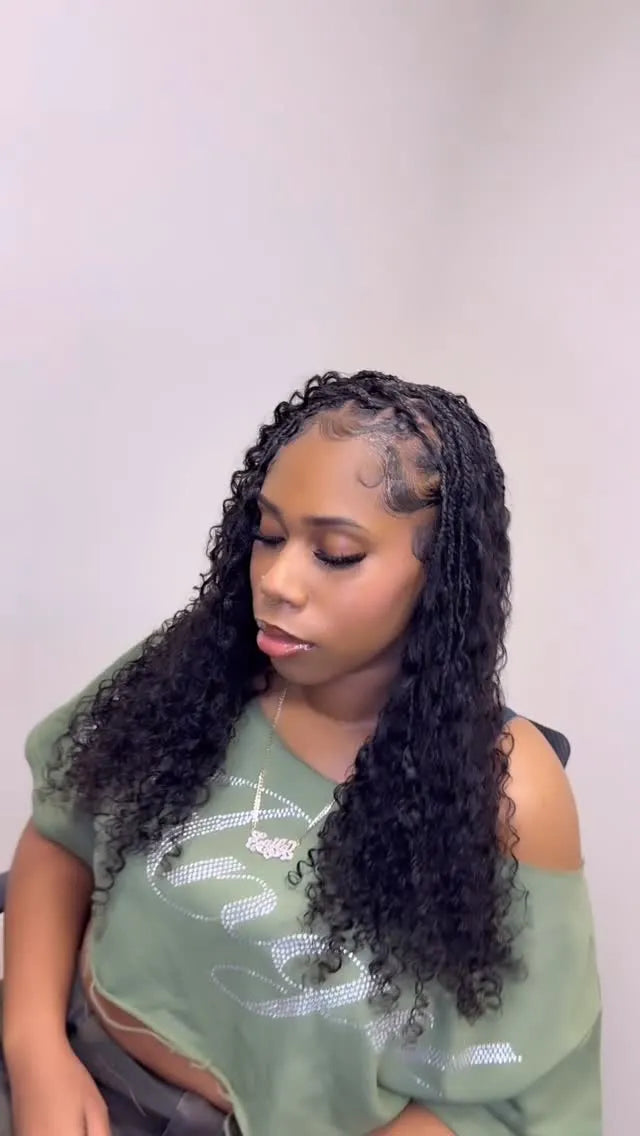 Woman with styled hair wearing a green top against a plain background