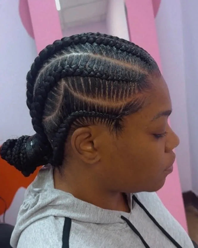 Feed-in cornrows with curved stitch patterns gathered into a low braided ponytail, hairstylist in Memphis, TN