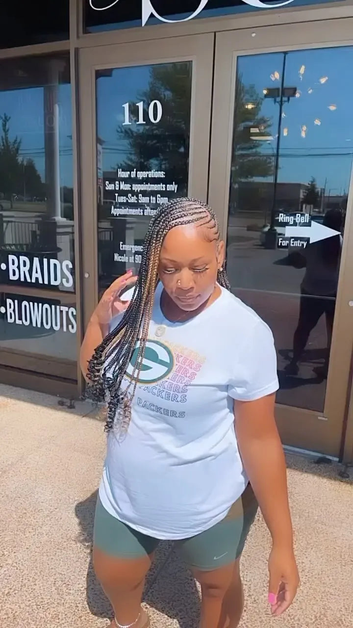 Side-swept feed-in braids with curled ends and blonde highlights, hairstylist in Memphis, TN