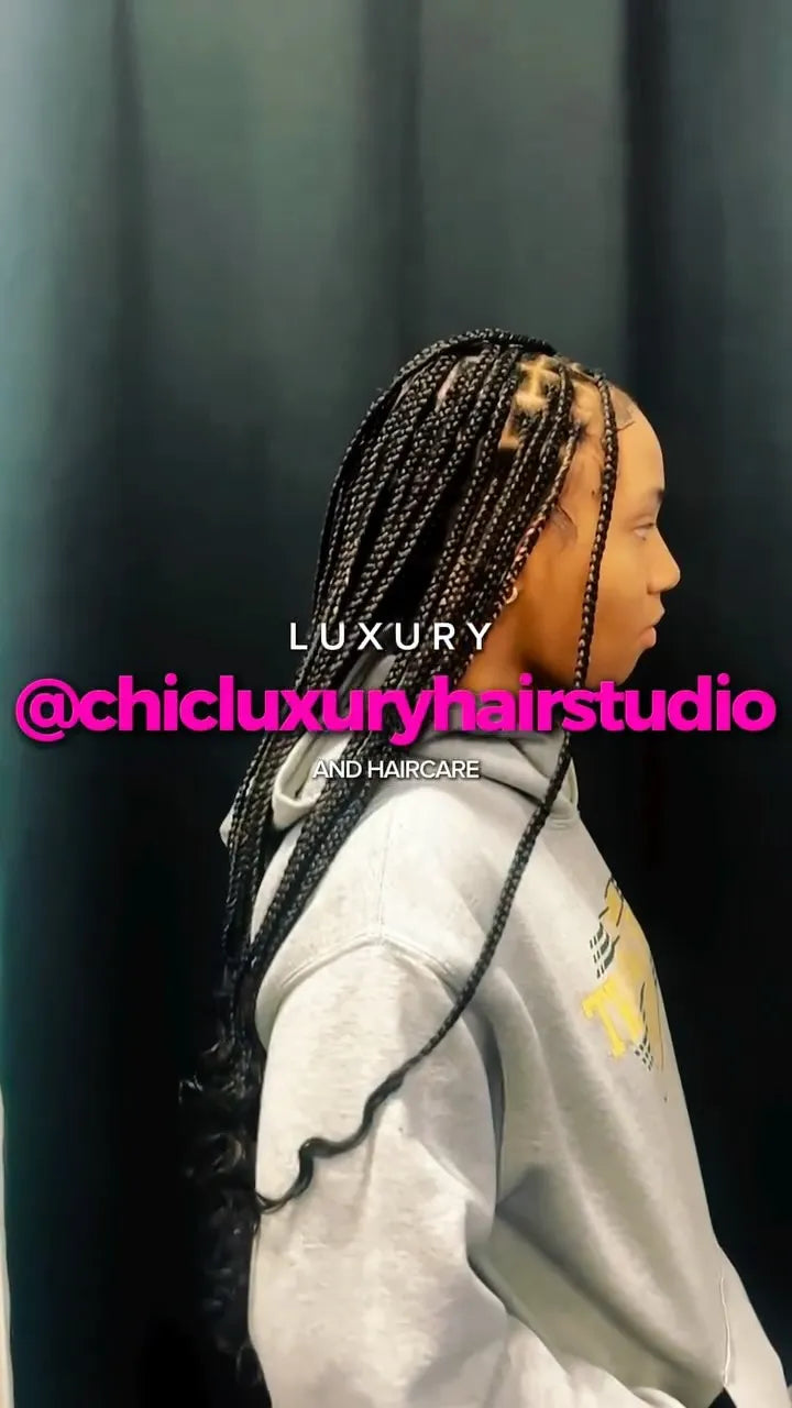 Long black knotless braids with clean parting and curly ends, hairstylist located in Franklin Square, NY