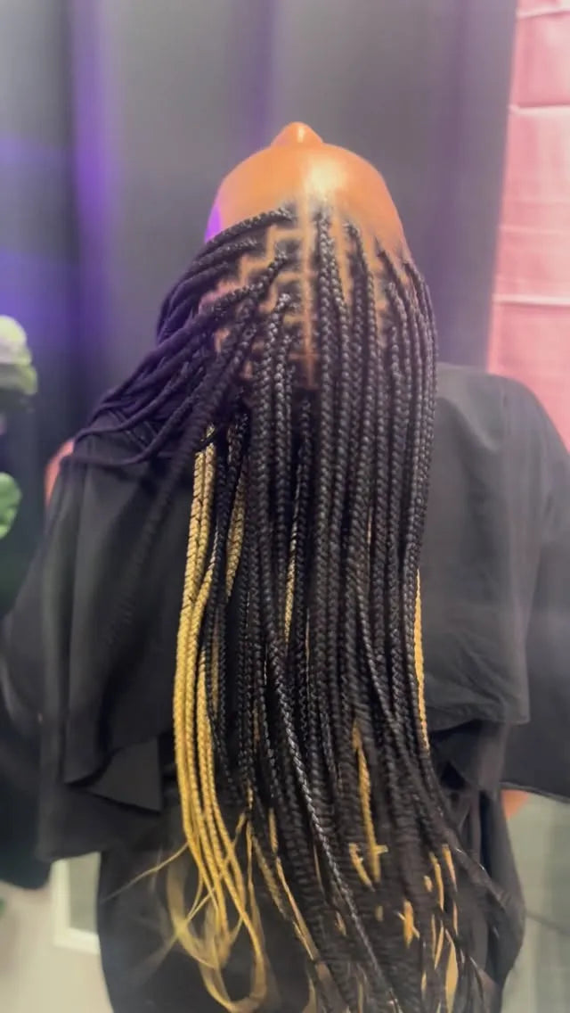 Long black knotless box braids with blonde peekaboo highlights, hairstylist located in Franklin Square, NY