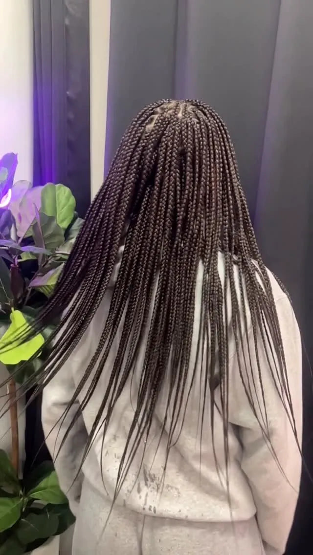 Long small brown box braids with sleek straight finish and clean parting, hairstylist located in Franklin Square, NY