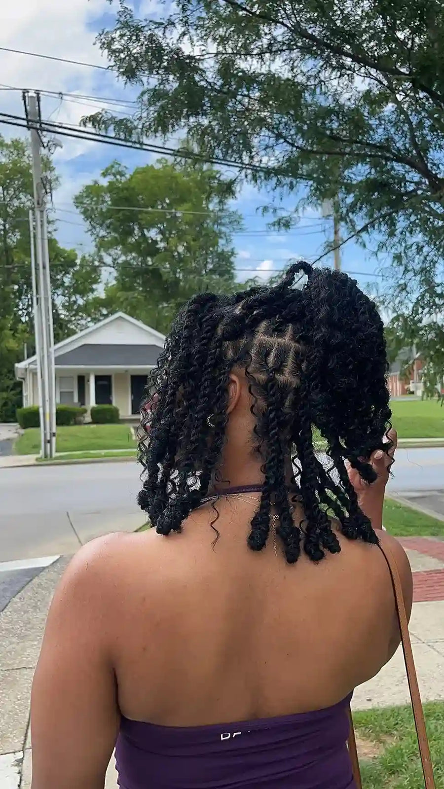 Short black curly locs styled in a half-up hairstyle with defined twists and textured ends, Stylist located in Bowling Green, KY