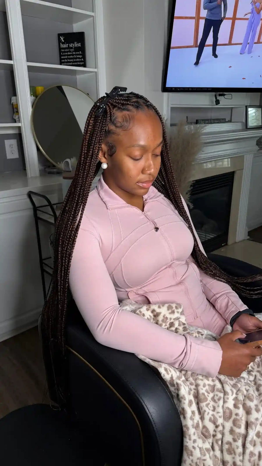 Woman sitting on a massage chair using a remote control in a living room setting.