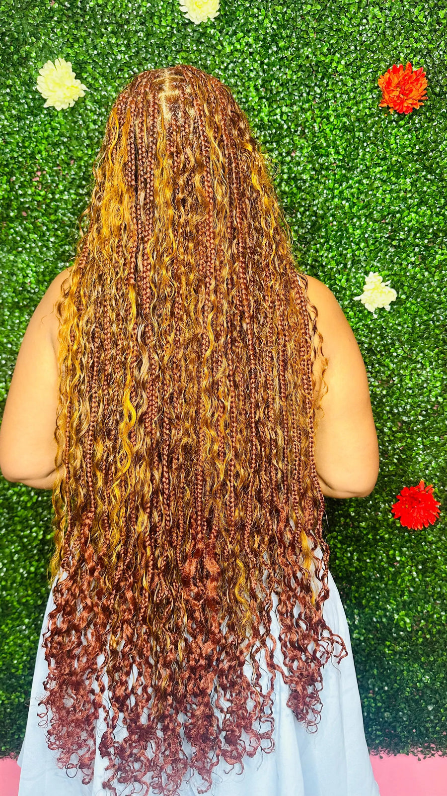 Person with long, styled hair against a green textured background with flowers.
