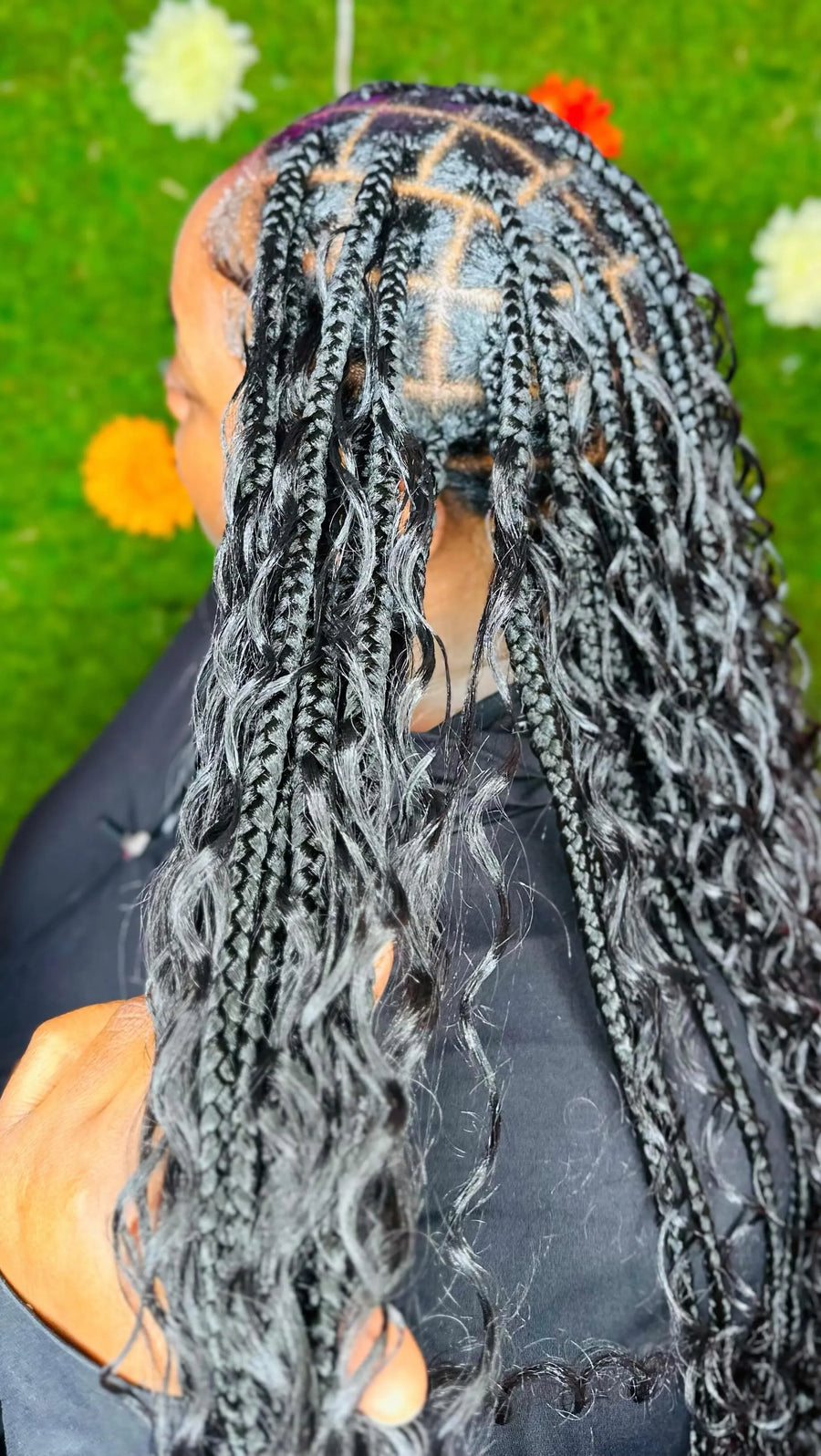 Person with braided hair against a green background