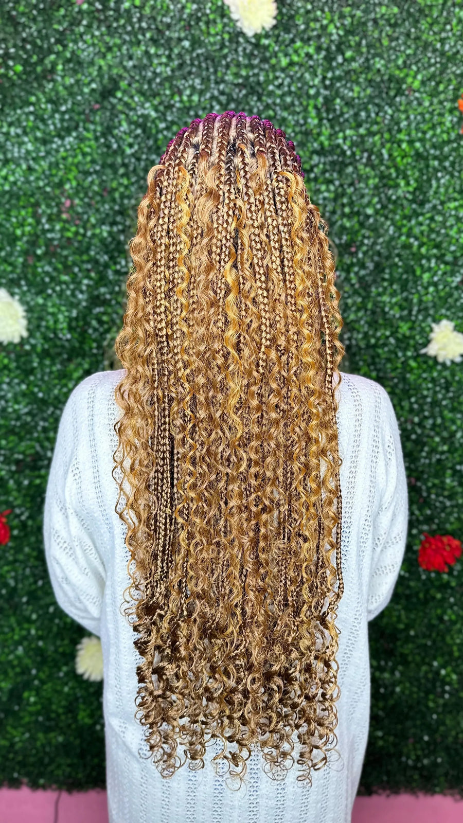 Person with long, styled hair against a green textured background