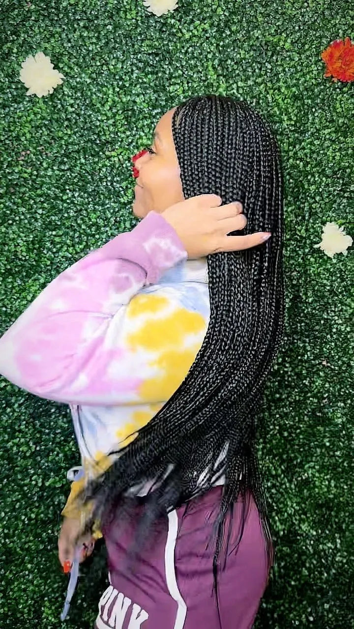 Person with braided hair lying on grass