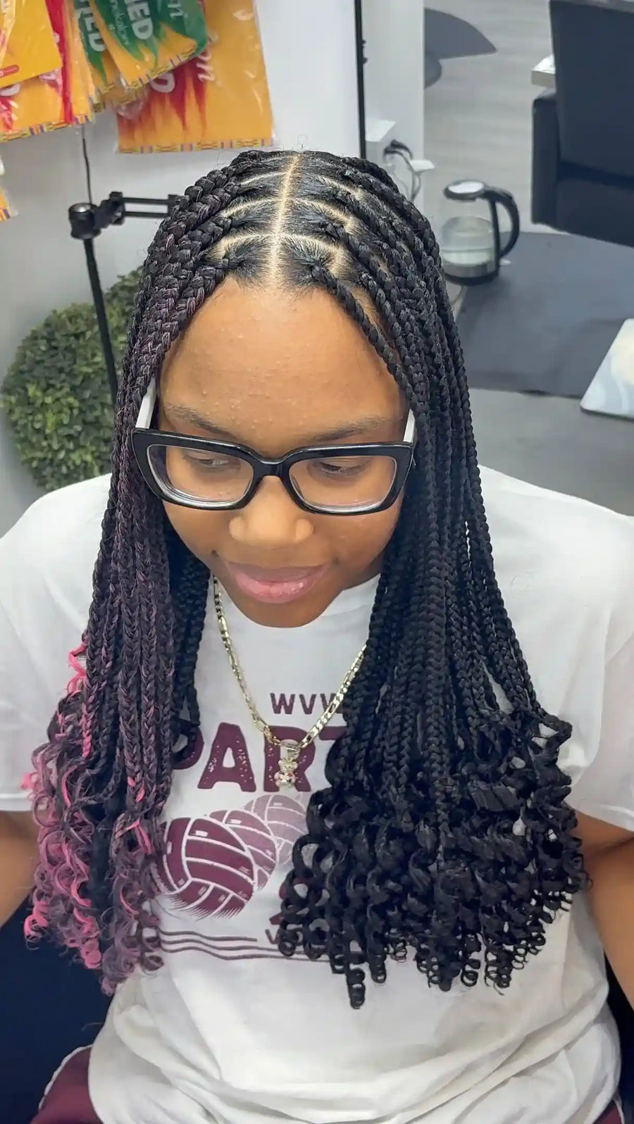 Medium knotless braids with a center part, black and pink highlights, and curled ends, hairstylist located in Wilkes-Barre, PA