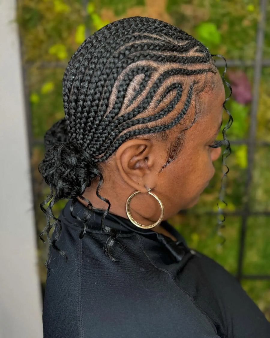 Intricate feed-in cornrow braids with curved side design and low braided bun, hairstylist in Brooklyn, NY