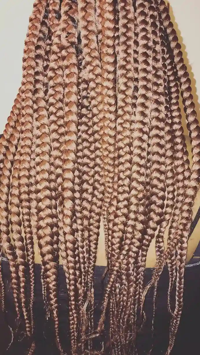 Long honey-brown jumbo box braids with smooth plaited texture, hairstylist located in Bettendorf, IA