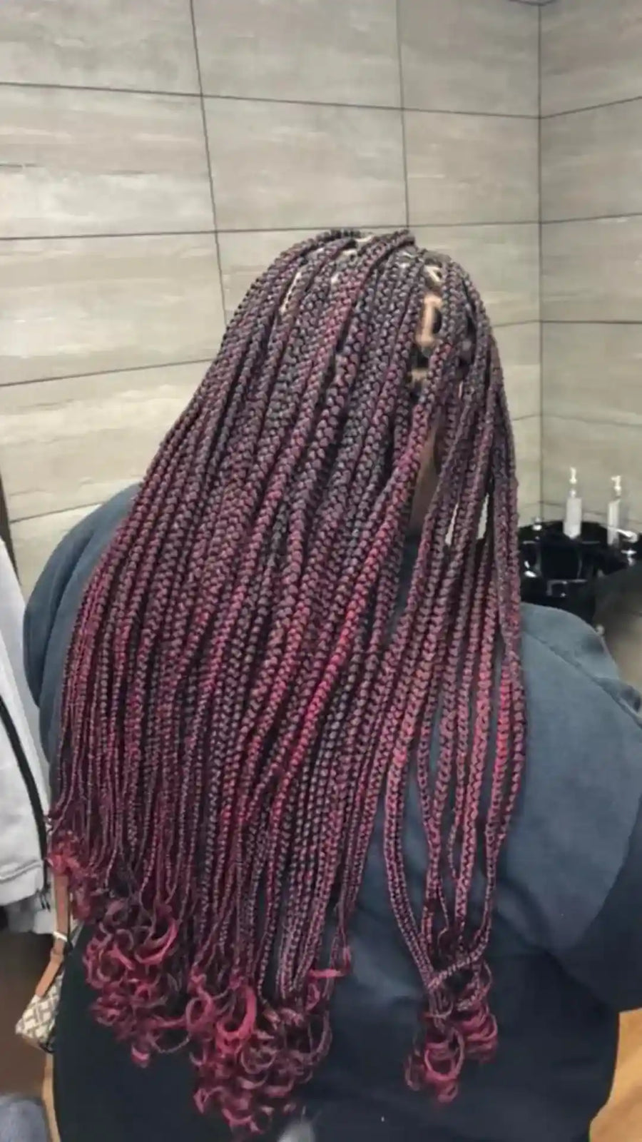 Long burgundy knotless box braids with curled ends, hairstylist located in Bettendorf, IA