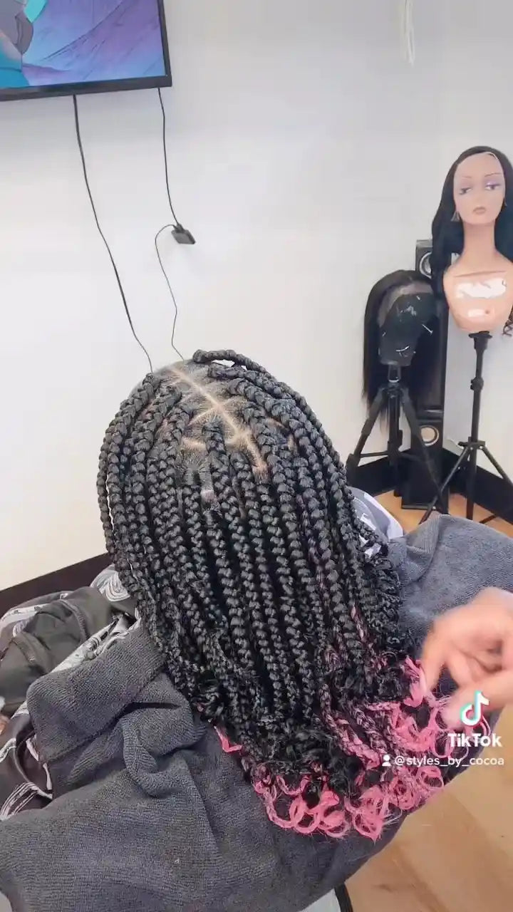 Shoulder-length black knotless box braids with bright pink curly ends, hairstylist located in Bettendorf, IA
