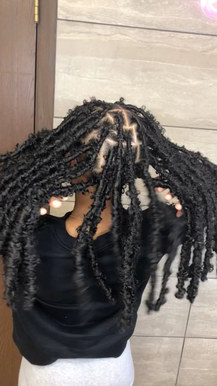 Chunky black distressed faux locs with neat geometric parting, hairstylist located in Bettendorf, IA