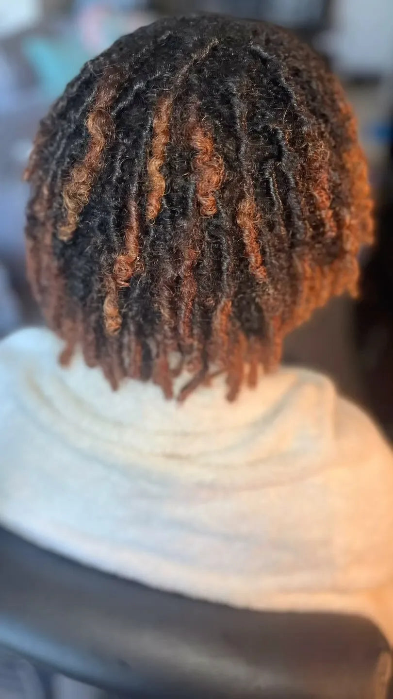 Short black loc bob with warm copper highlights and textured ends, hairstylist located in Bettendorf, IA