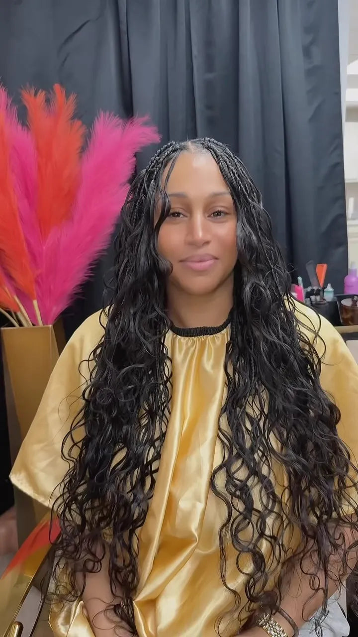 Extra-long black boho knotless braids with loose curly strands and a center part, hairstylist located in Jacksonville, FL