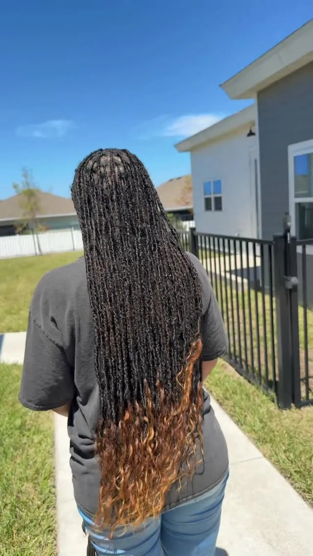 Long black boho braids with loose curls and subtle golden accent strands, hairstylist located in Jacksonville, FL