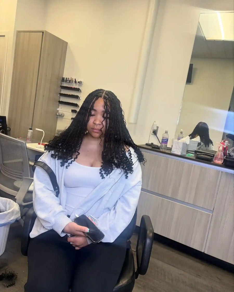 Medium island twists with loose curly ends and center part, hairstylist in Buffalo, NY