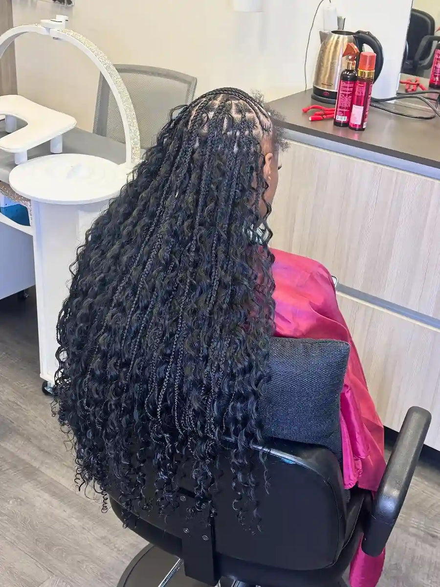 Long copper red boho braids with loose curls and center part, hairstylist in Buffalo, NY