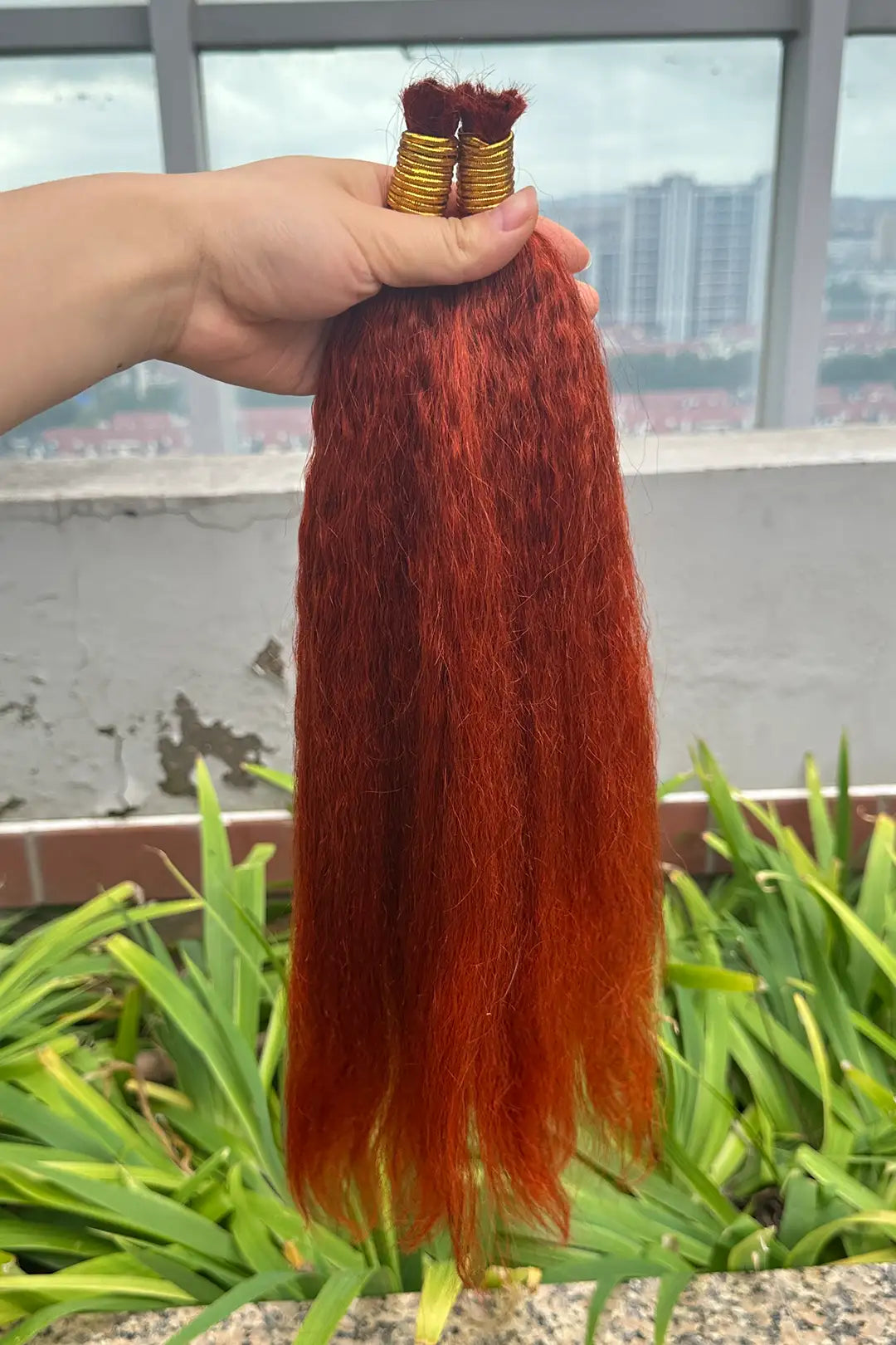 Outdoor picture of 350 ginger kinky straight bulk human hair for braiding bu17