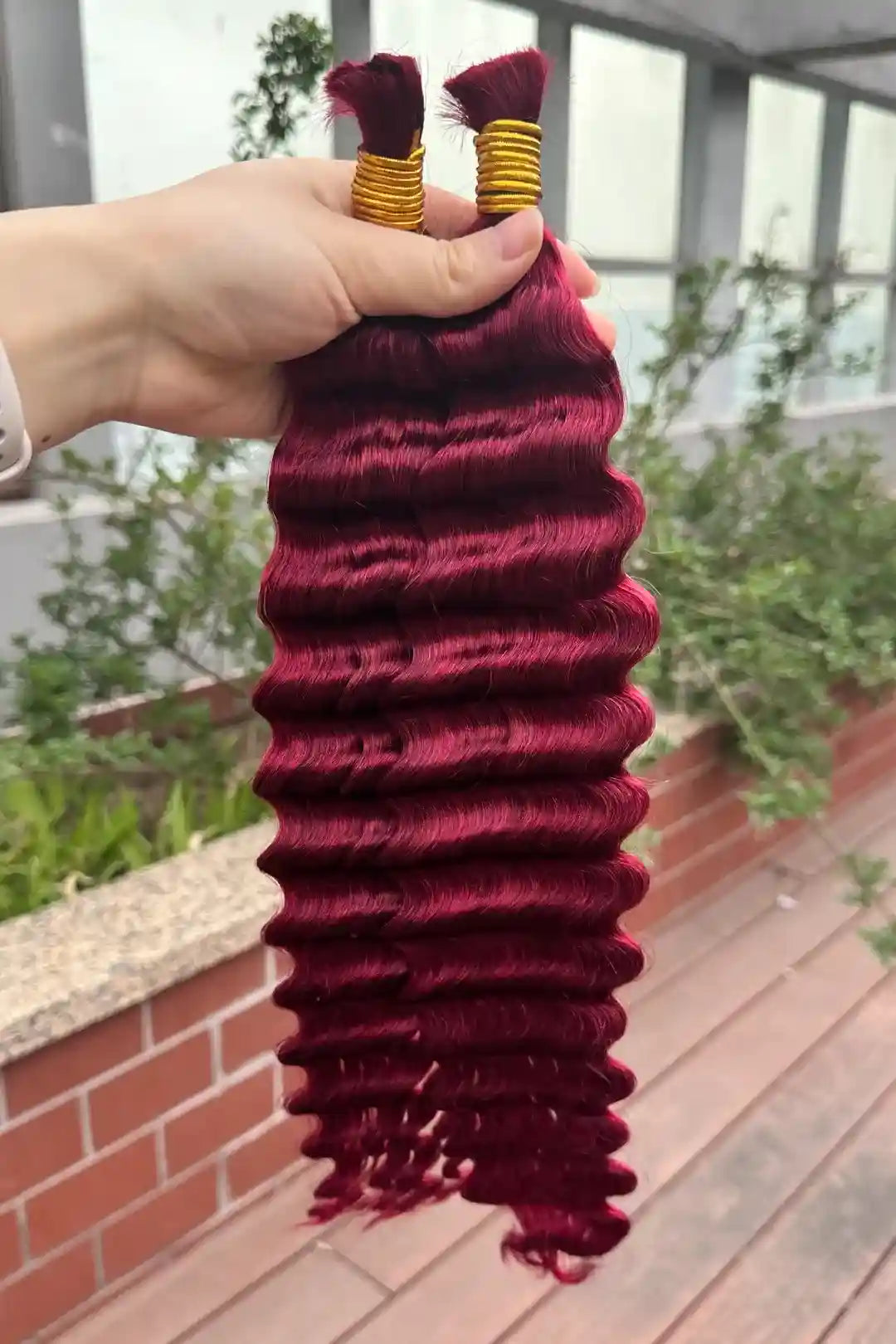 Outdoor picture of the ends of bulk human hair for braiding burgundy red deep wave bu19