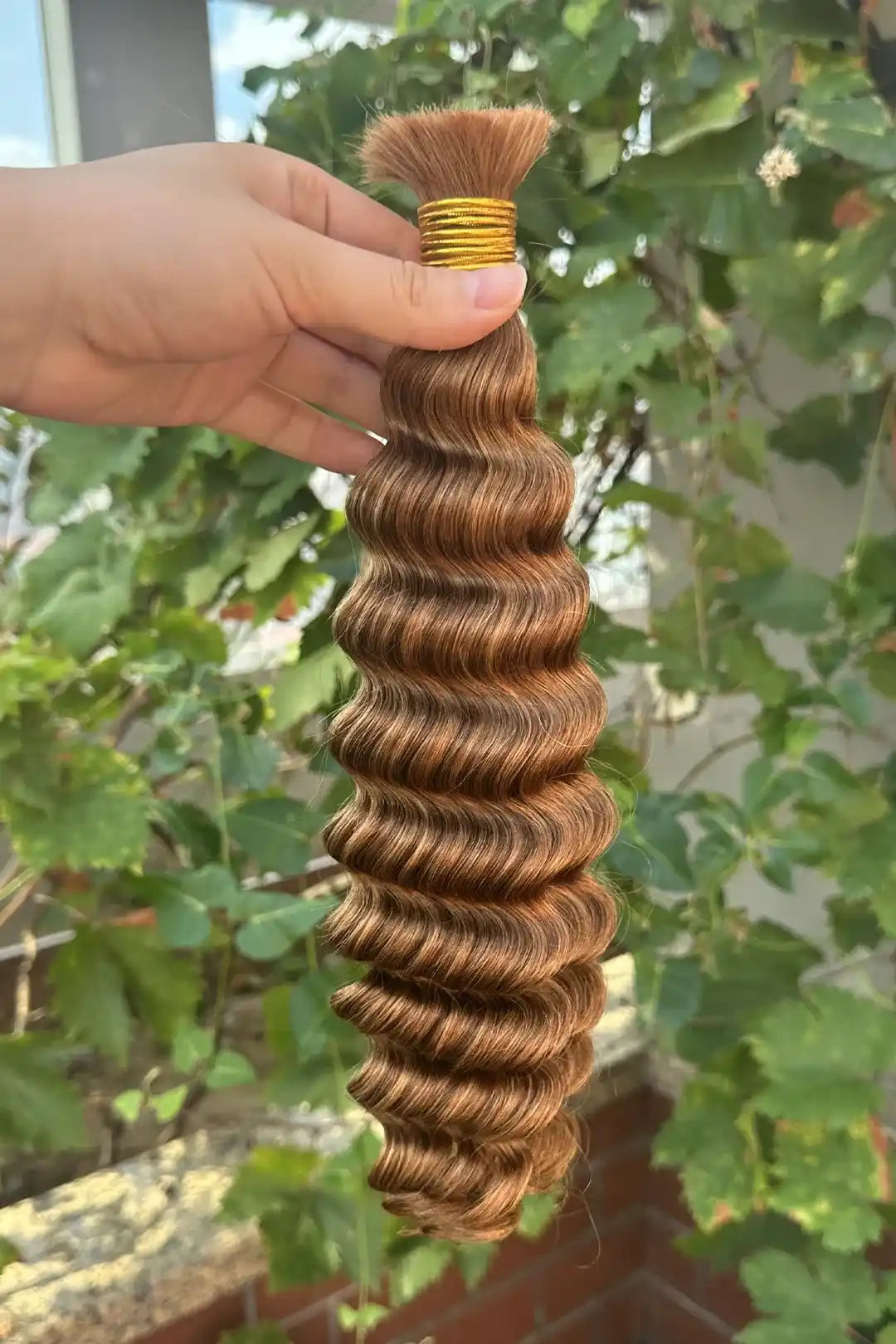 Outdoor picture of double drawn 30a light auburn bulk hair deep wave bu46
