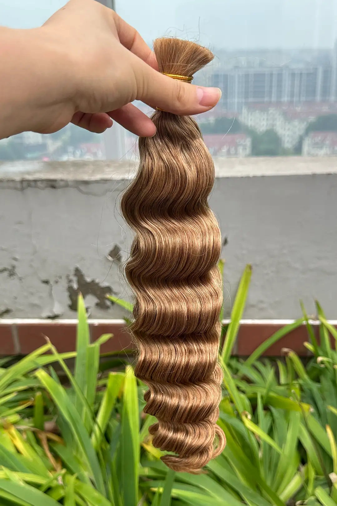 Outdoor picture of double drawn 27 honey blonde bulk hair loose wave bu65