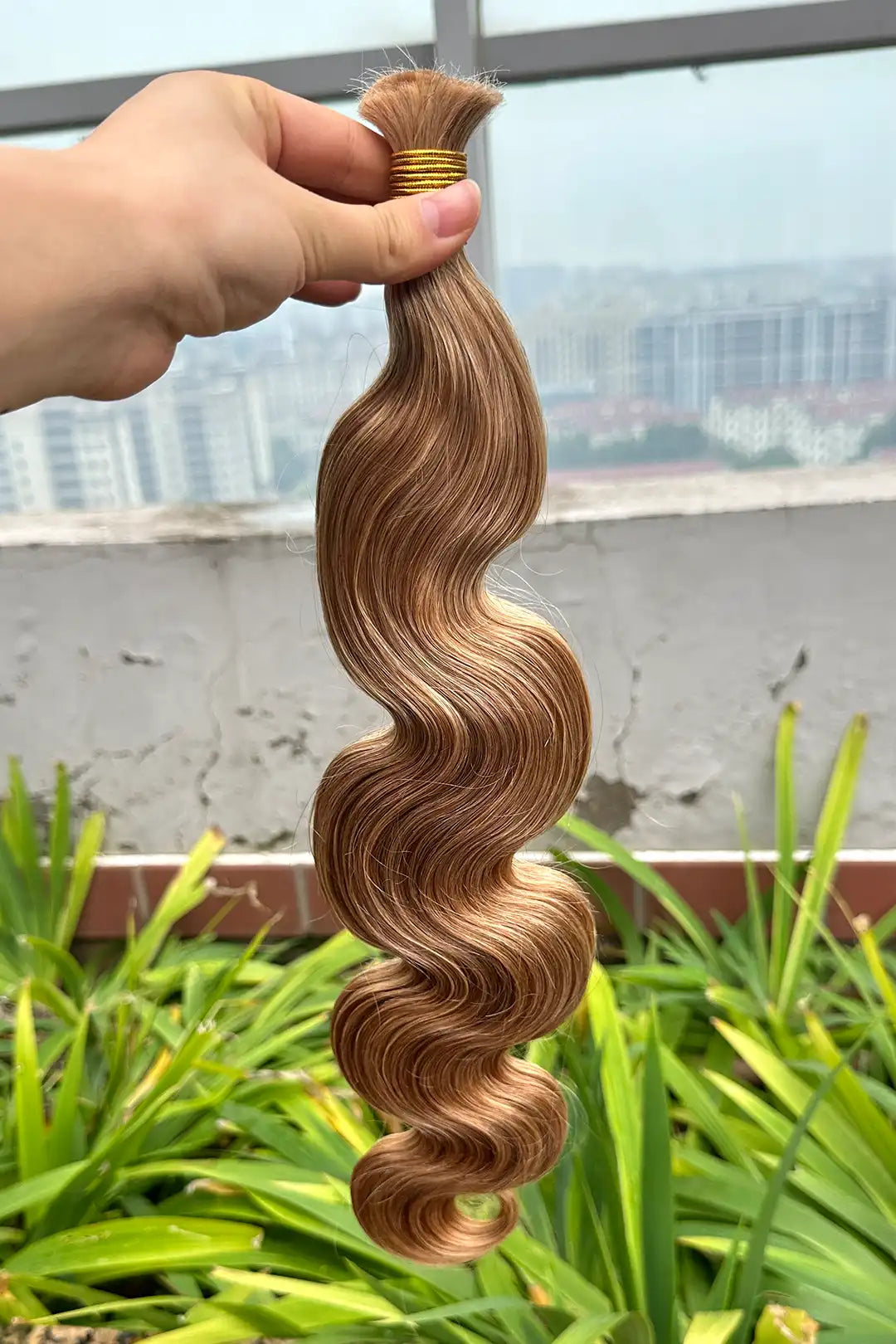 Outdoor picture of double drawn body wave medium blonde bulk hair bu58