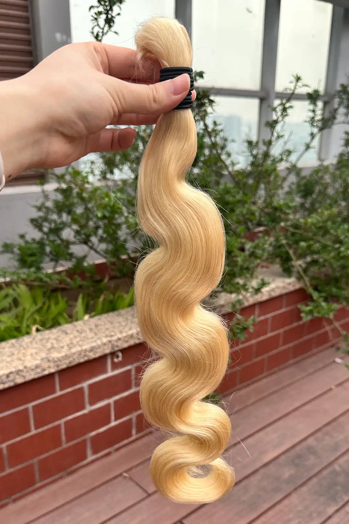 Outdoor picture of single drawn 613 blonde body wave bulk human hair for braiding