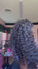 Tiktok influencer binka.luv shows the braiding process of loose deep wave feather crochet hair extension