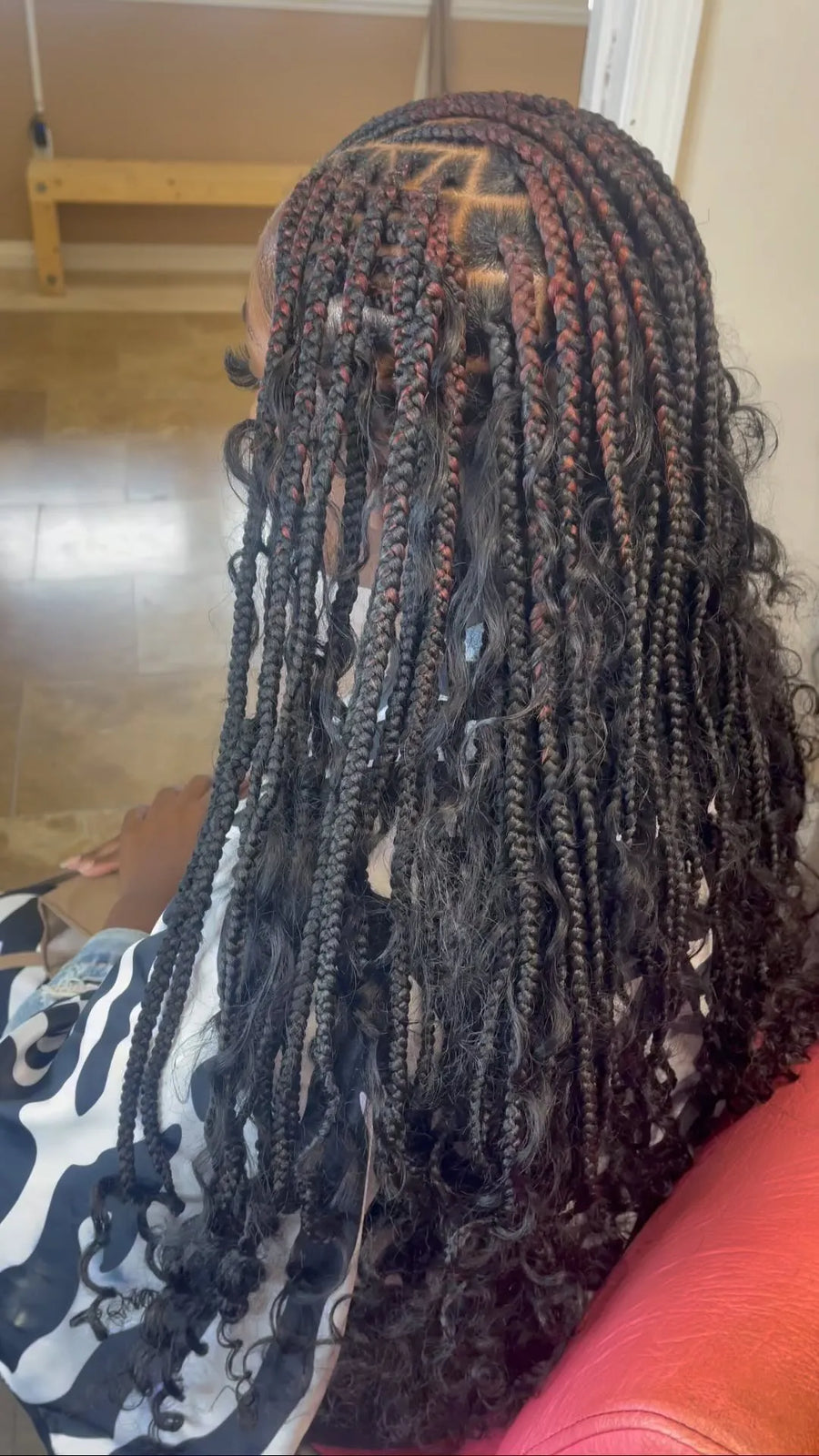 Medium boho knotless braids with curly ends and burgundy highlights, hairstylist in Westland, MI